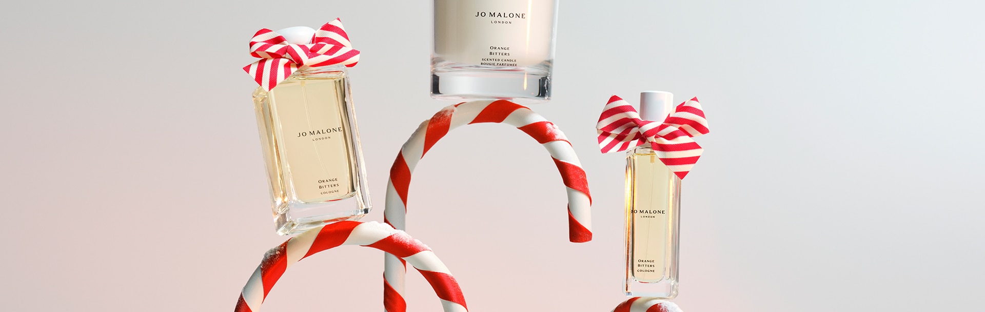 Jo Malone London Orange Bitters Collection Candle Cologne with red and white bows on red and white candy canes